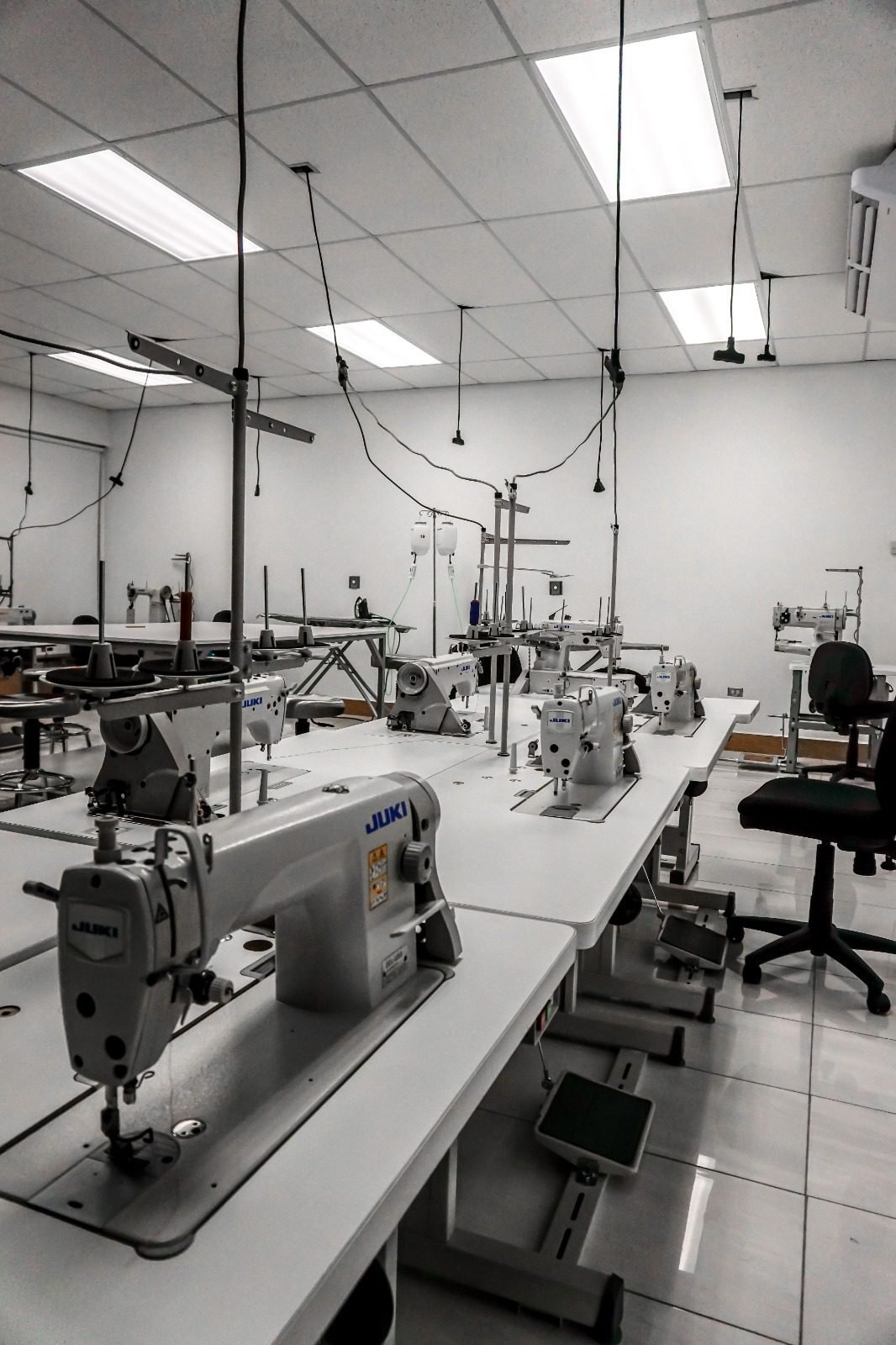 Rows of industrial lockstitch machines in an apparel workshop between runs