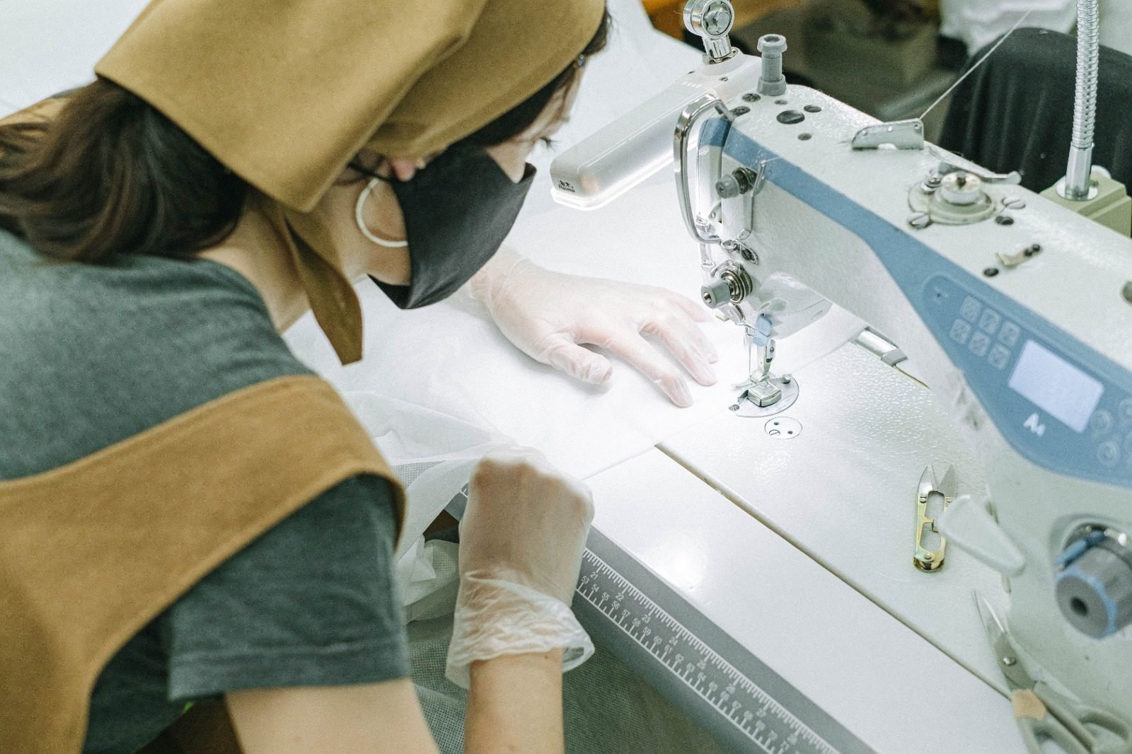 A machinist stitching sheer fabric at a computerised industrial lockstitch machine