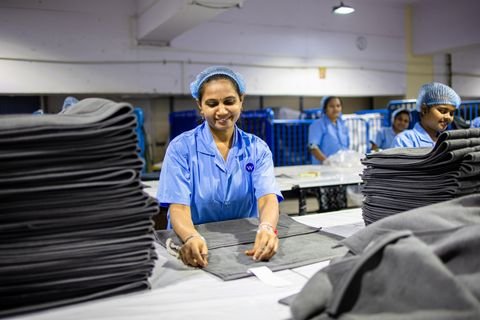 Workers folding finished fabric in a textile factory