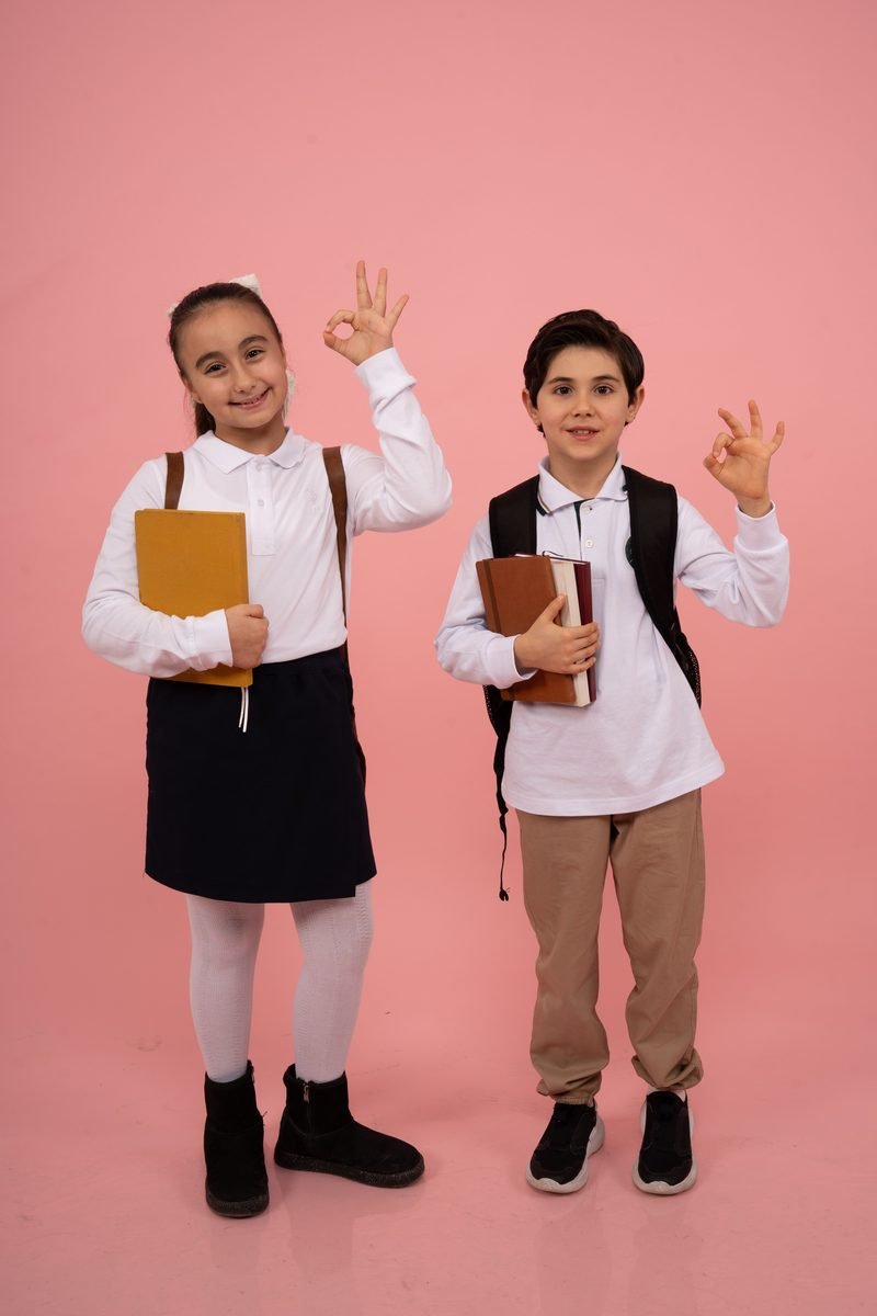 Two schoolchildren in white uniform shirts